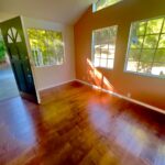 Bright living room with clean hardwood floors and windows after professional deep cleaning in Los Angeles