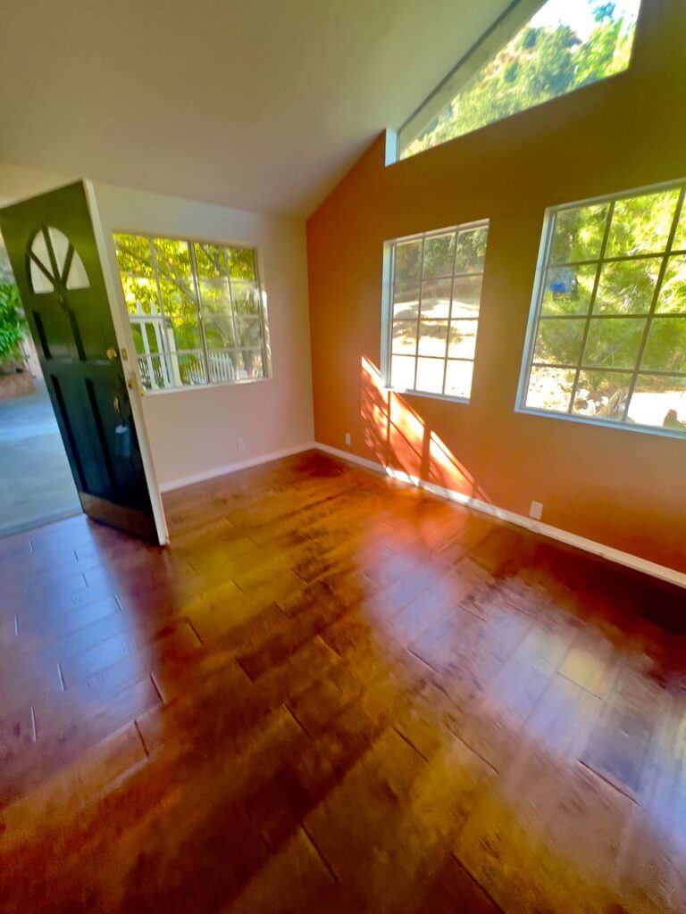 Bright living room with clean hardwood floors and windows after professional deep cleaning in Los Angeles