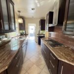 Spacious kitchen with dark wood cabinets and tile floor after deep cleaning service in Los Angeles