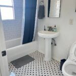 Bathroom with white tile floor, cleaned sink and toilet after deep house cleaning in Los Angeles