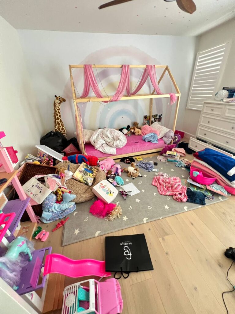 Messy kids room with toys scattered on the floor before professional organization and cleaning.