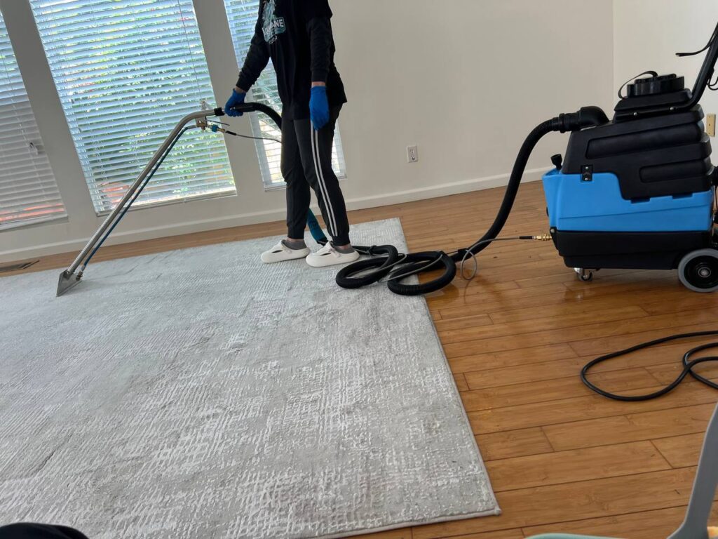 Technician cleaning carpet in Los Angeles apartment using low-moisture method