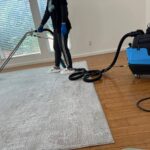 Technician cleaning carpet in Los Angeles apartment using low-moisture method