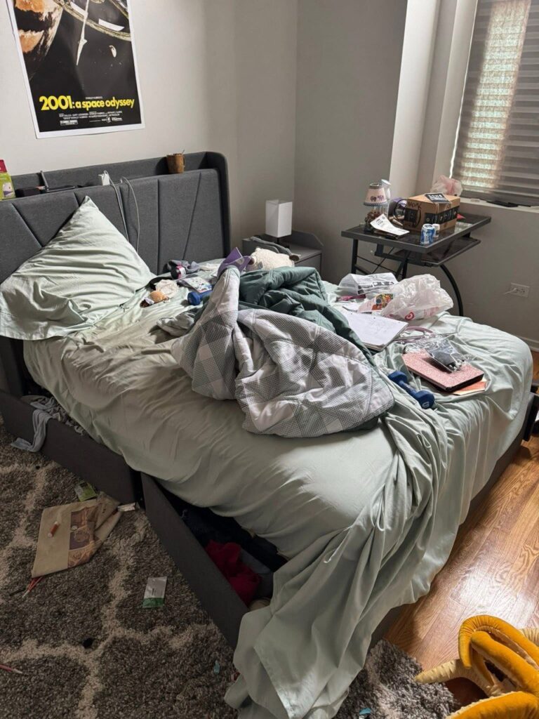 Cluttered bedroom before professional organizing service — unmade bed, clothes and items scattered.